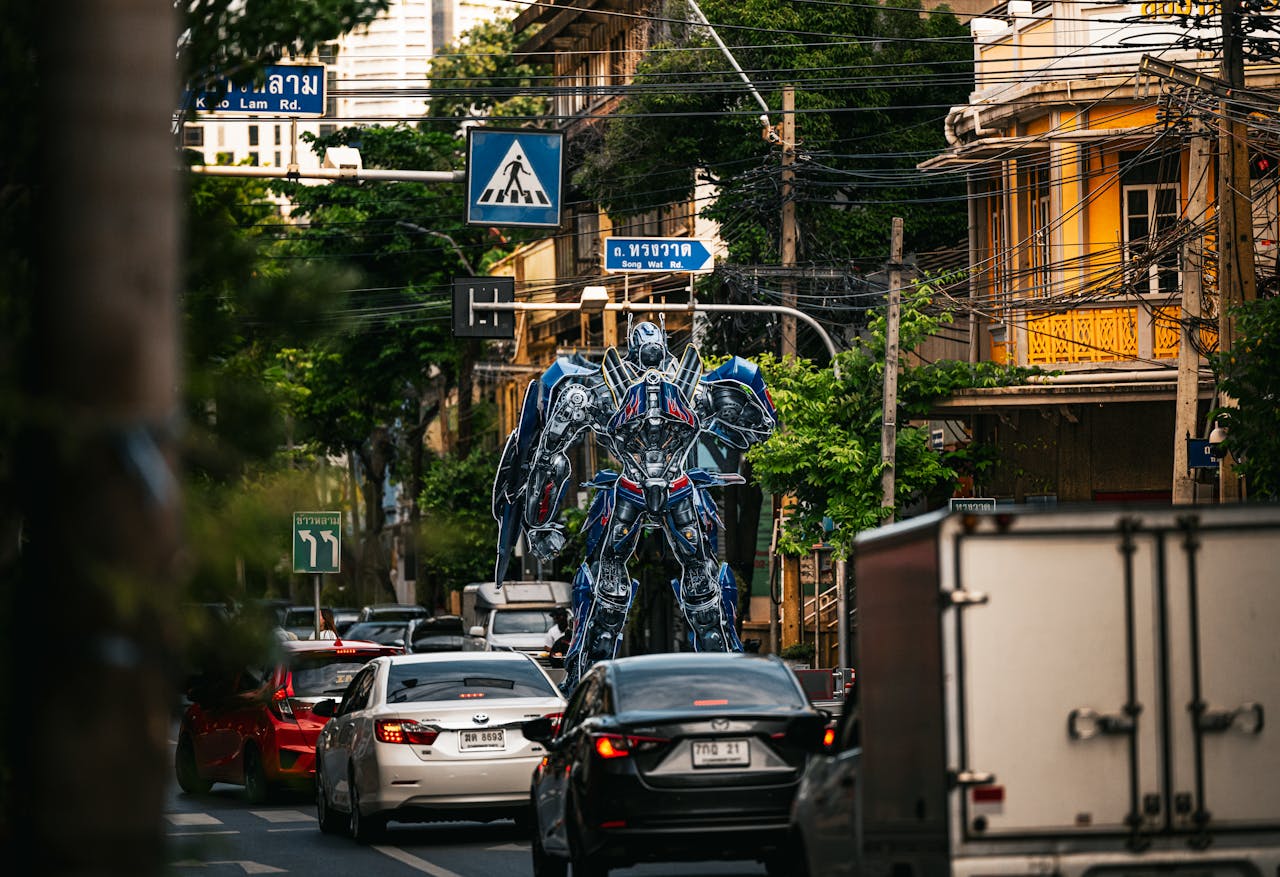 A towering robot statue stands amidst bustling traffic on a street in Bangkok, Thailand.