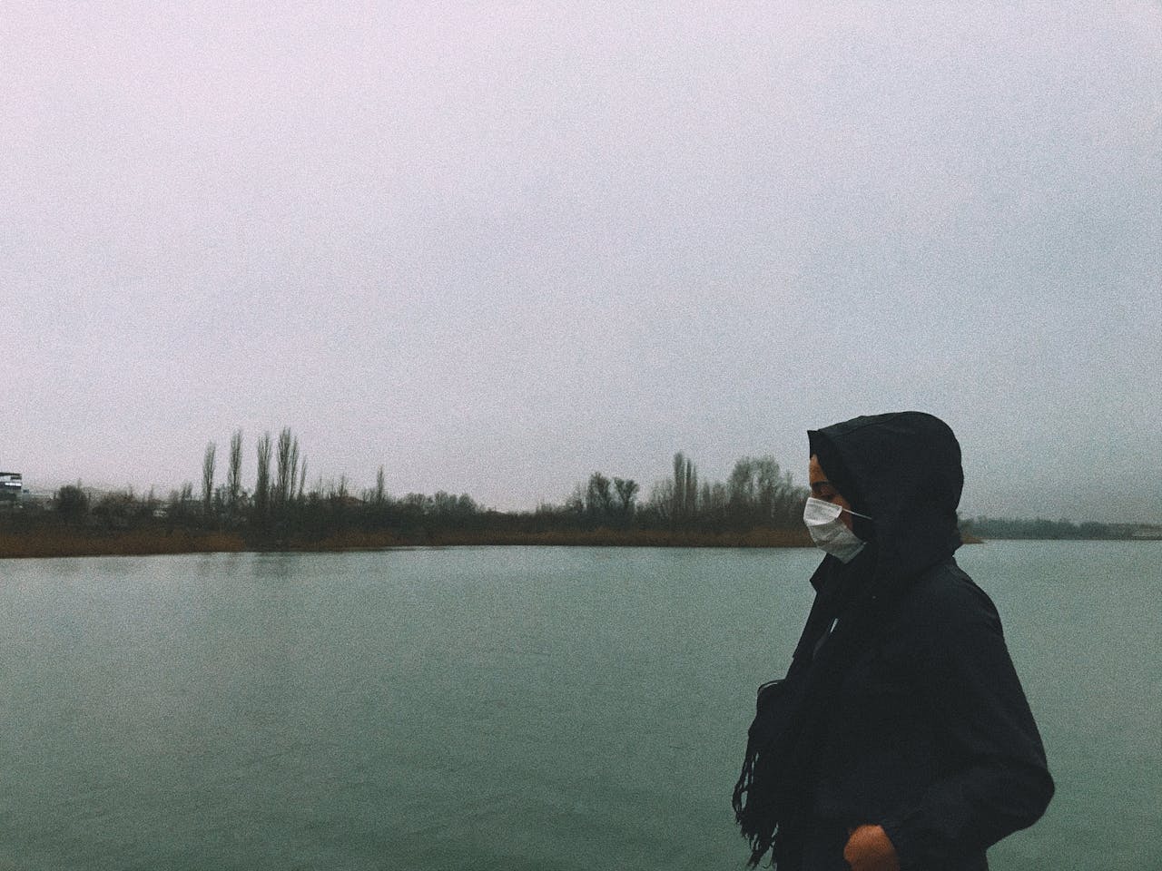 A person wearing a mask stands by a lake in Gölbaşı, Turkey, reflecting the new normal.